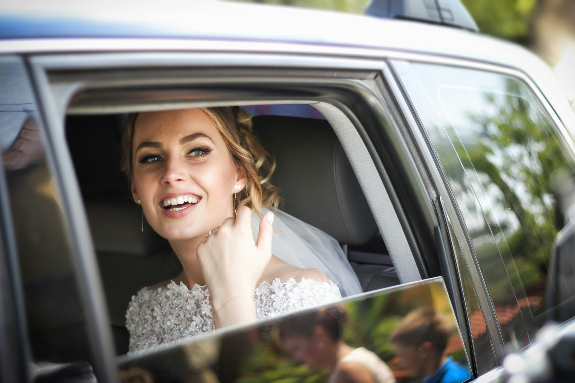 Bride smiling from a luxury bridal car in Los Angeles