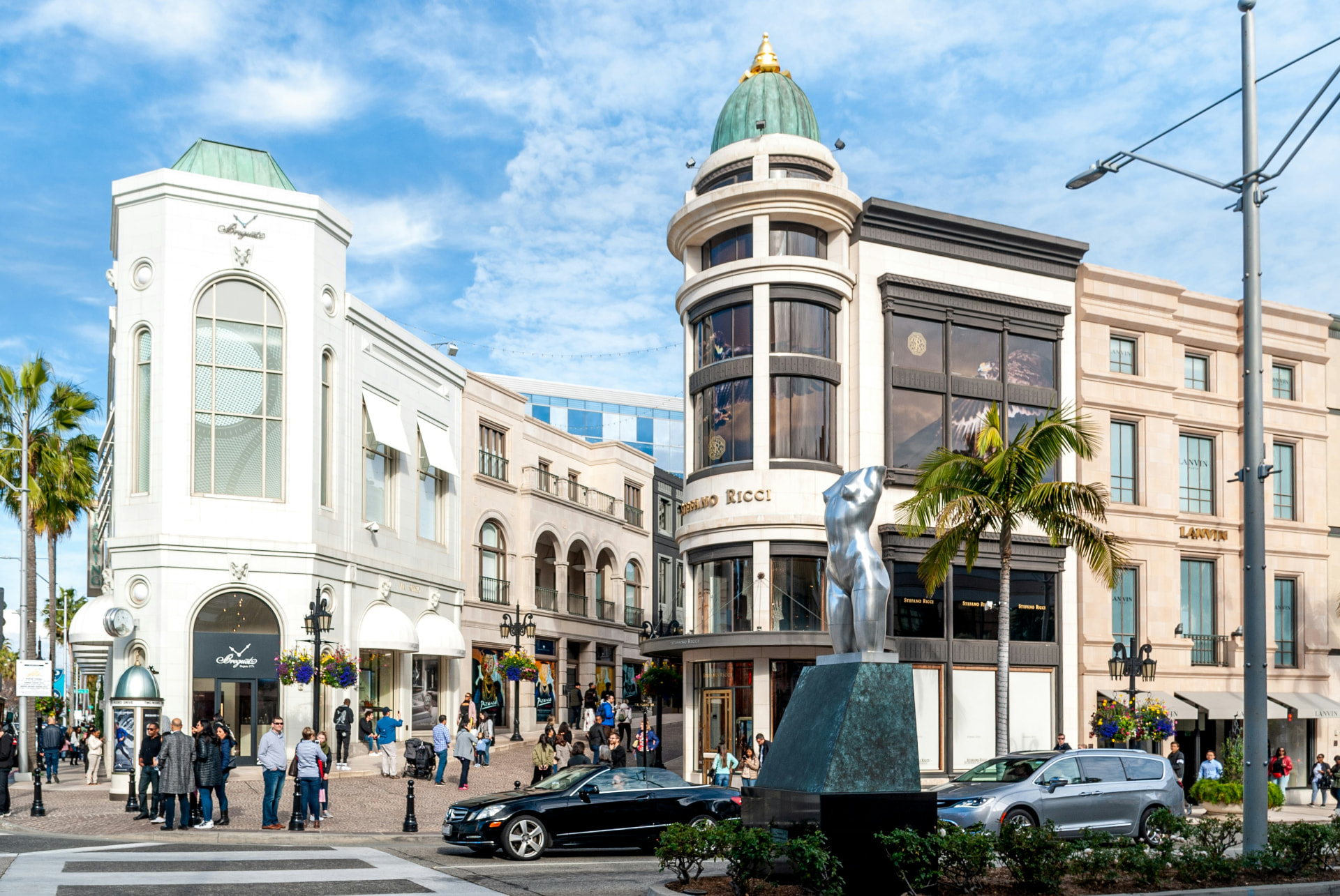 Black luxury sedan traveling through Rodeo Drive