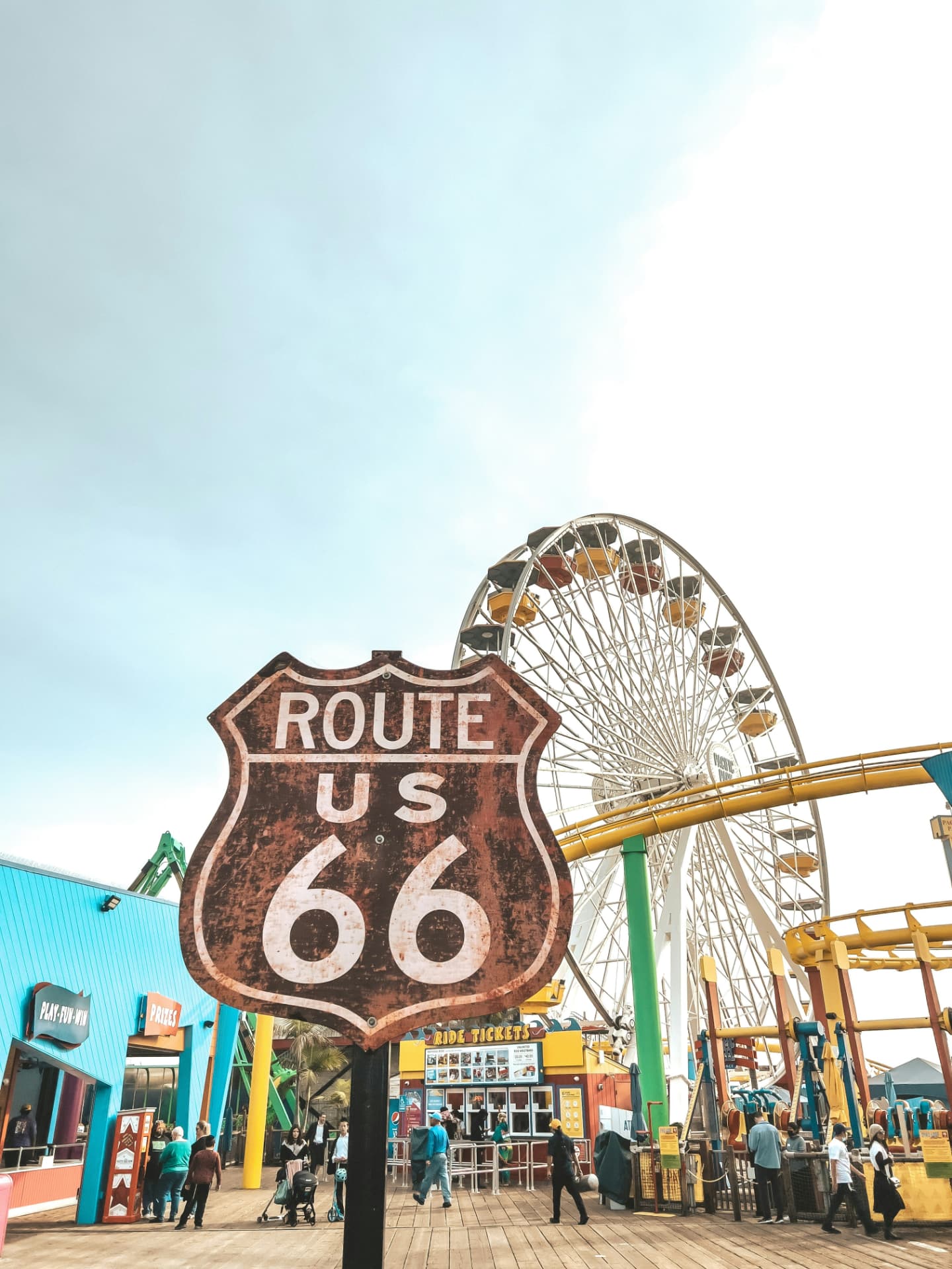 Route 66 sign and Ferris wheel on the Santa Monica Pier boardwalk