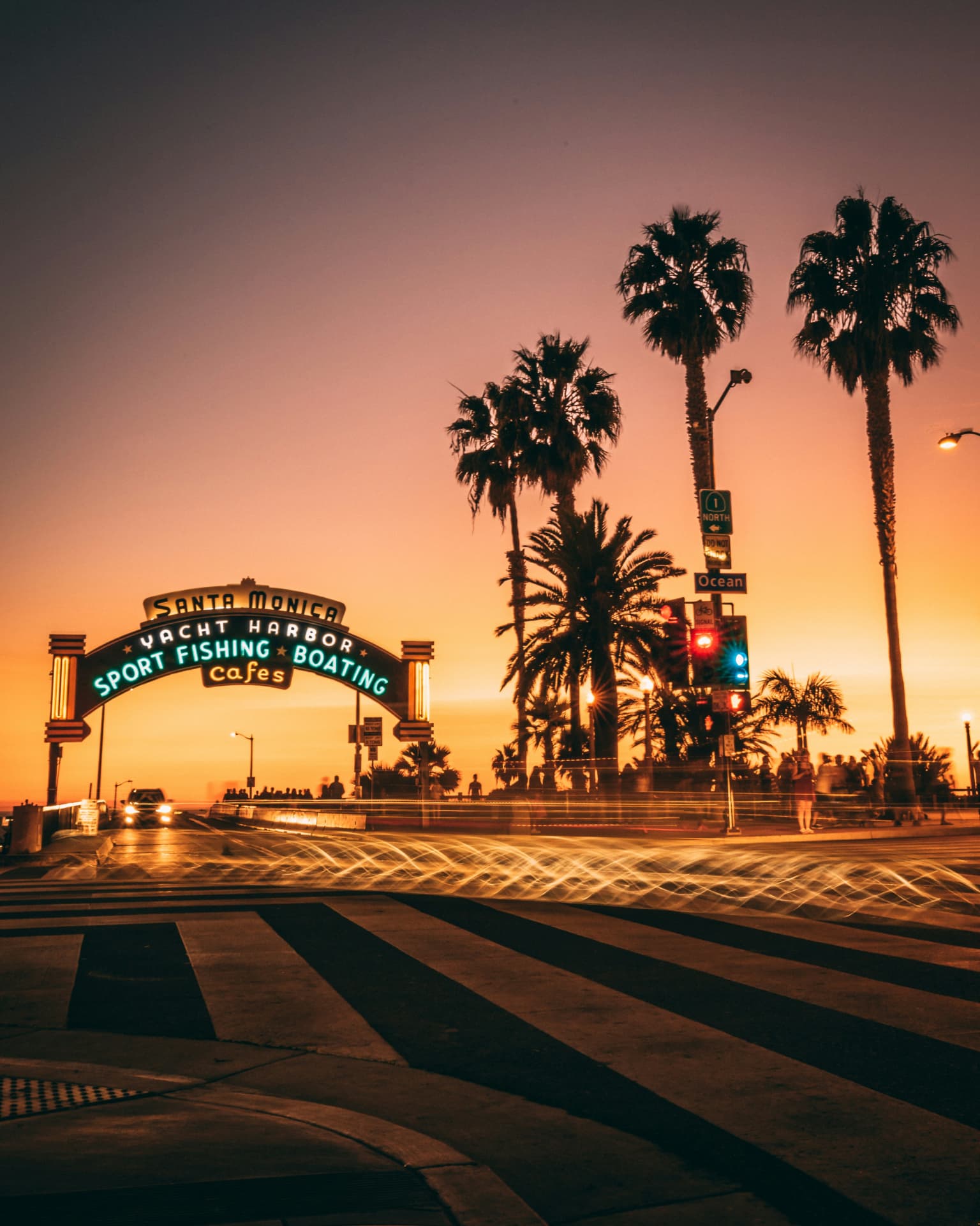 Santa Monica Pier sign glowing at sunset